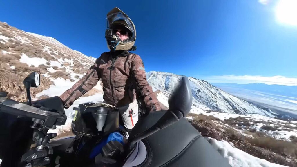 Regardez deux aventuriers s'attaquer à une route de montagne enneigée vers une ville fantôme
