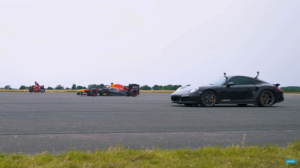 Vélo KTM MotoGP contre.  Voiture Red Bull F1 contre.  Porsche 911 TurboS