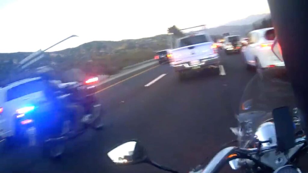 Regardez un conducteur bloquer intentionnellement un motocycliste qui traverse sa voie et se faire arrêter
